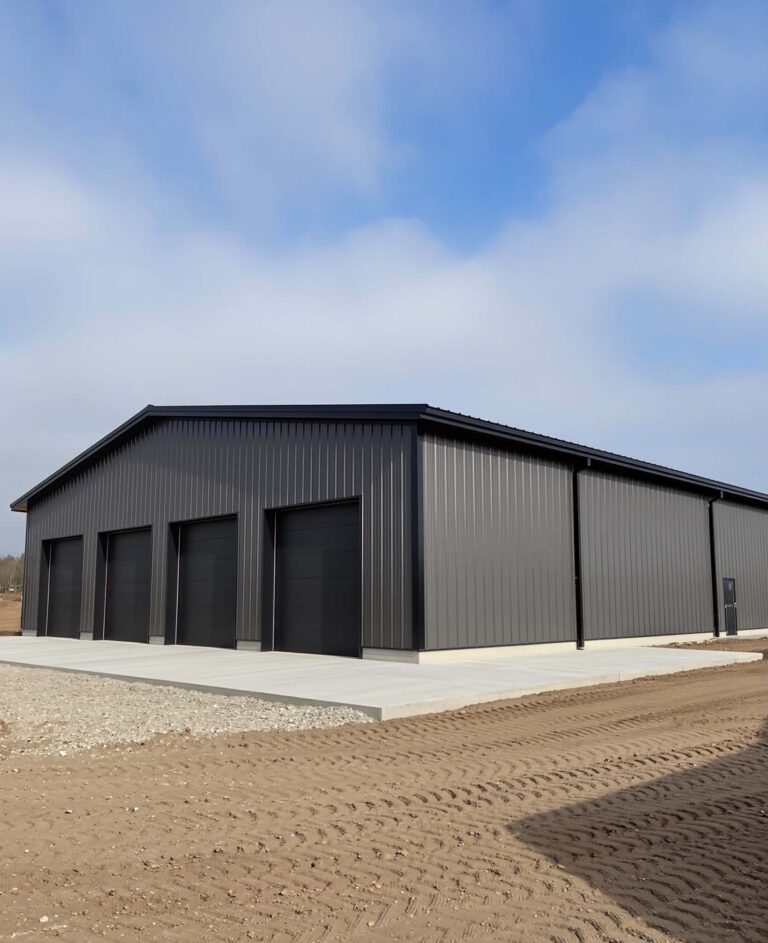 Modern black steel garage building with four overhead doors on a concrete slab, ideal for residential storage, workshops, and equipment in Central Valley, California